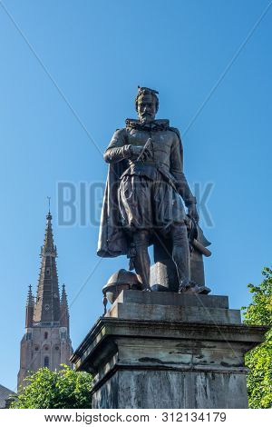 Bruges, Flanders, Belgium -  June 17, 2019: Simon Stevin Statue With Spire Of Olv Cathedral In Back 
