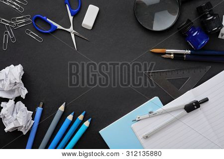 school supplies on black chalkboard background. back to school