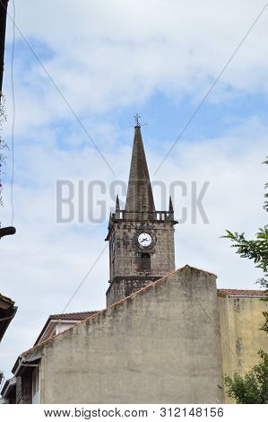 Bell Tower Of Church Of San Cristobal Located In The Center Of The Villa On A Cloudy Day In Comillas