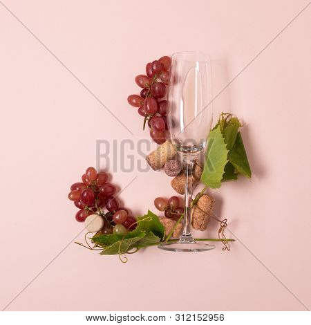 Alphabet. Letter J Made Of Wineglasses With Rose And White Wine, Grapes, Leaves And Corks Lying On P