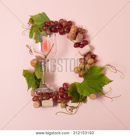 Alphabet. Letter D Made Of Wineglasses With Rose And White Wine, Grapes, Leaves And Corks Lying On P