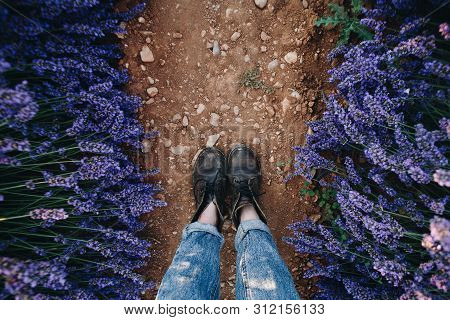 Pov Shot From Above On Woman Feet In Brown Leather Vintage Boots And Raw Denim Jeans Stand On Path O