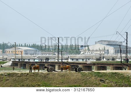 North Korea, Kaesong - May 4, 2019: Countryside Life, Dprk. Two Men In Military Uniform Stands Next 