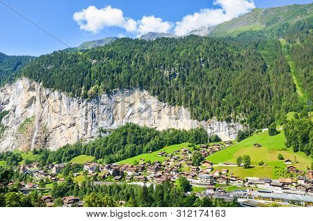 Amazing View Of Picturesque Swiss Village Lauterbrunnen In Summer From Above. Famous Staubbach Falls