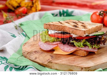 New Years Sandwich With Sausage, Tomatoes, Cheese, Sauce And Lettuce On A Wooden Board. Against The 
