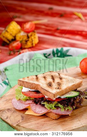 New Years Sandwich With Sausage, Tomatoes, Cheese, Sauce And Lettuce On A Wooden Board. Against The 