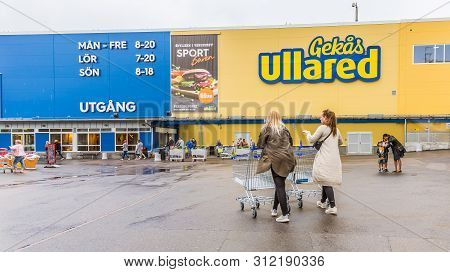 Two Women With Shopping Carts Walking To The Entrance Of Gekås Ullared, Sweden, June 16, 2019