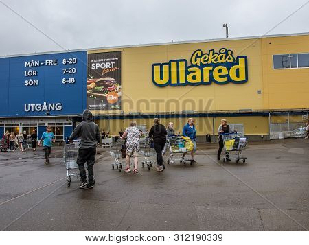 People With Shopping Carts Walking To The Entrance Of The Gekås, Ullared, Sweden, June 16, 2019