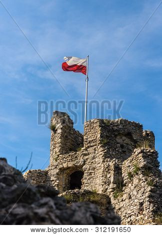 Polish Flag In Famous Ogrodzieniec Castle In Polish Jurassic Highland, Silesia Region In Poland