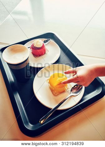 Closeup Of Kids Child Hand Trying To Steal Tasty Cakes From Plate On Tray. Impatient Person Taking F