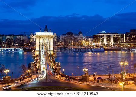 Nineteenth Century Chain Bridge (szechenyi Lanchid) And Budapest Cityscape At Night. Budapest, Hunga