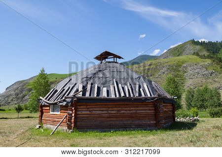 The Ancient Antique Ail House From Wood Is Round-shaped With A Chimney On Top Of The Center, For The