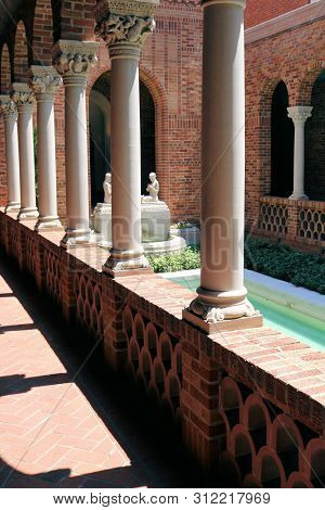 June 29, 2019 In Eugene, Or:  Vintage Building Including Columns Besides A Walkway And A Courtyard W