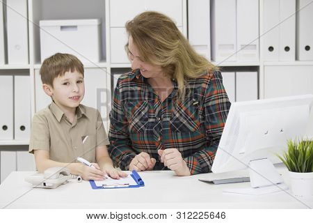 Teacher With A Primary School Student.mom In The Office With A Child