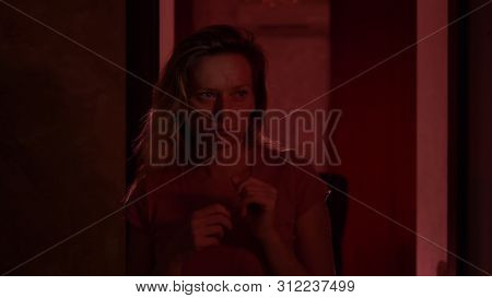 A Woman Experiences Fear And Panic While Walking In A Dark Corridor. Horror Maniac Concept. Hallowee