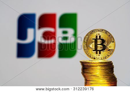 Gold Bitcoin Coins With The Jcb Logo On Background Screen. A New Type Of Business Finance Concept. T