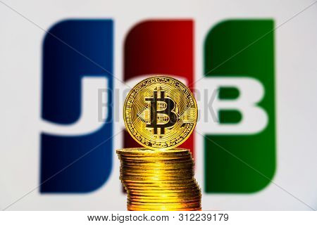 Gold Bitcoin Coins With The Jcb Logo On Background Screen. A New Type Of Business Finance Concept. T