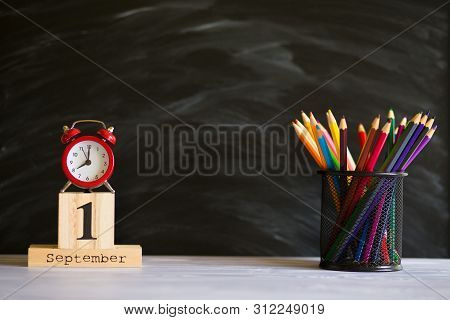 Concept Back To School. Re Alarm Clock With Color Pencils And Wooden Calendar Set On 1St September O