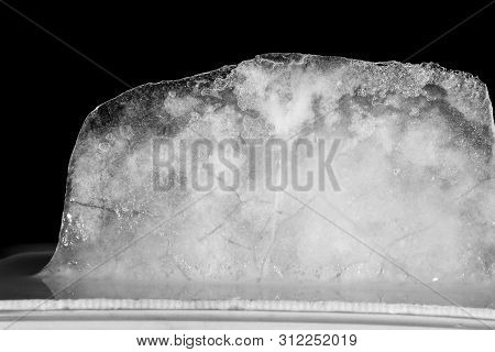 Ice Melting High Contrast, Black Background. Bubbles In Ice.