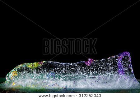 Colored Ice Melting On Black Background. Glitter And Colors!