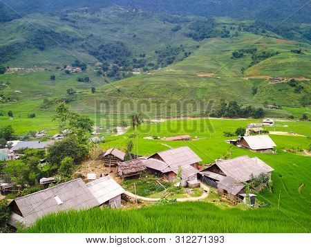 Bright Green Rice Fields Surrounded By Local Village And High Mountains. Travel And Explore The Worl