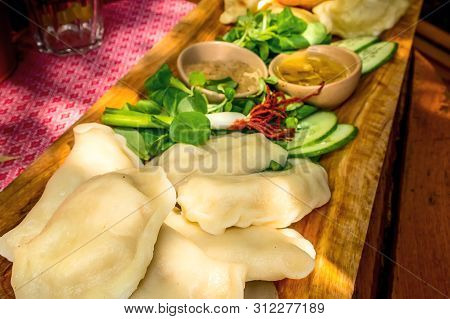 Varenyky, Vareniki, Polish Pierogi, Pyrohy Or Dumplings On The Wooden Board With Green Salad, Tradit