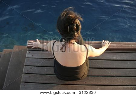 Woman Sitting On A Pier