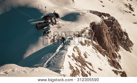 Landscape View Of The Mountain Hut Kredarica From The Mali Triglav. Two Alpinist Climbing To The Top