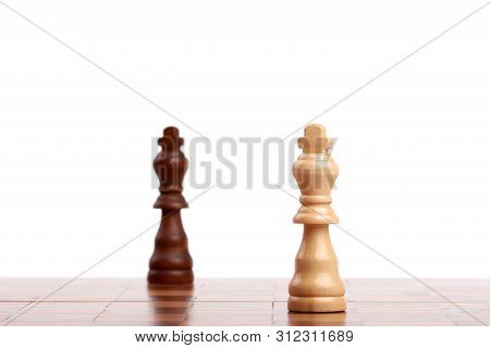 Two Wooden Chess Pieces, Black And White King On The Board. Strategy And Victory Isolated On White B