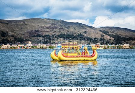 Uros, Peru - Jan 5, 2019. Traditional Totora boat with tourists on Titicaca lake near to the Uros floating islands , Puno, Peru, South America.