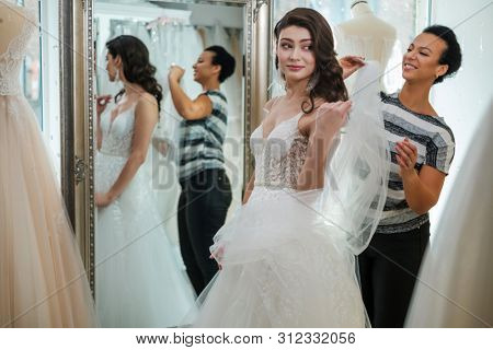 Beautifu bride choosing wedding dress in a wedding salon