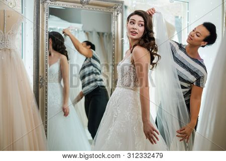 Beautifu bride choosing wedding dress in a wedding salon