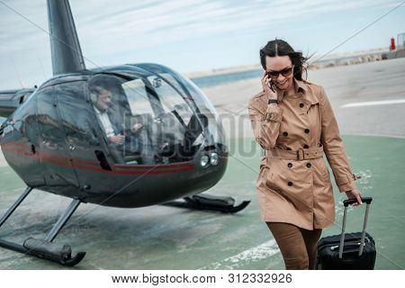 Business woman near private a helicopter
