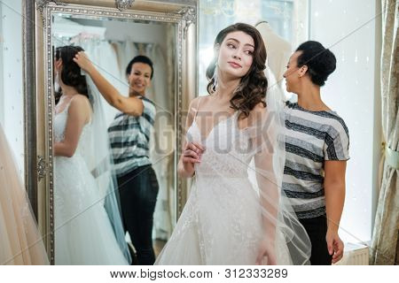 Beautifu bride choosing wedding dress in a wedding salon