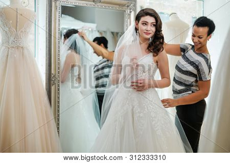 Beautifu bride choosing wedding dress in a wedding salon