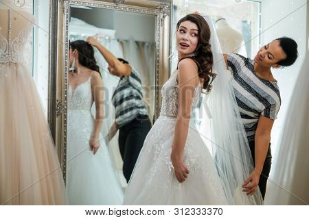 Beautifu bride choosing wedding dress in a wedding salon