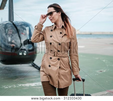 Business woman near private a helicopter
