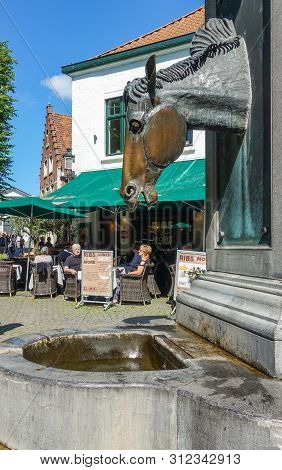 Bruges, Flanders, Belgium -  June 17, 2019: Gray Stone Water Pump With Horse Head As Faucet Especial