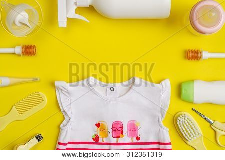 Baby Care Kit And Clothing On Yellow Background