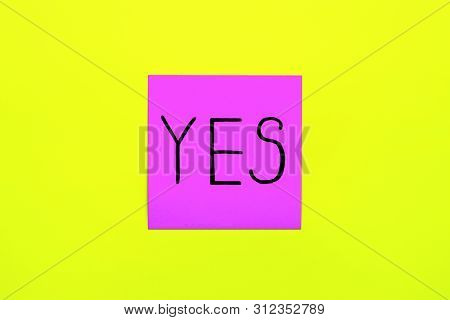 Close Up Black Handwritten Inscription Yes Word On One Purple Square Sticker On Yellow Background Wi