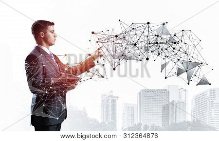 Business Person Pointing On Abstract Network Structure. Standing Personal Assistant In Business Suit