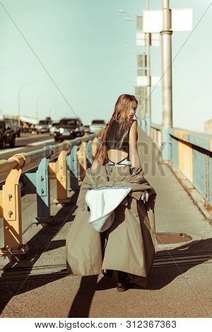 Sexy Drastic Long-haired Woman Taking Off Grey Coat