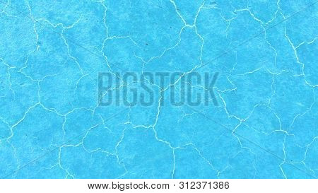 Beautiful Light Blue Background. Light Cracks On The Surface. Texture Of Old Paint. Blue Soil Drough