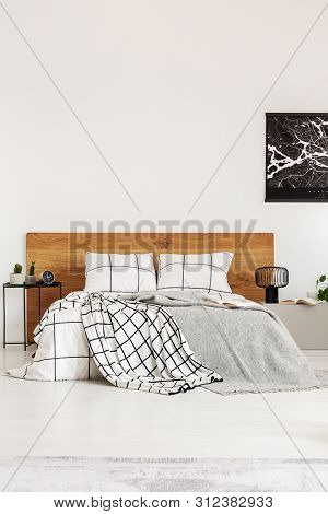 Black Map On White Wall Above Wooden Headboard In Simple Bedroom Interior
