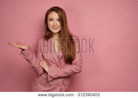 Young Woman Looks At The Camera Pointing Somewhere To The Side