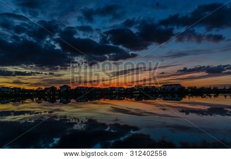 Beautiful Pink, Orange And Blue Sunset Reflecting On A Lake In A Subarban Neighborhood.