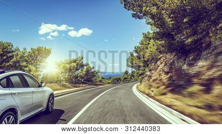 White Car Rushes Along The Road To The Sea.