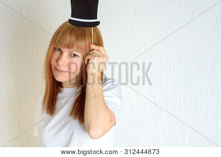 Attractive Happy Middle Aged Woman Having Fun With A Fake Hat On Stick. Female In The Period Menopau