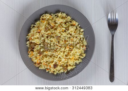 Rice With Small Pieces Of Meat And Carrot On Grey Plate