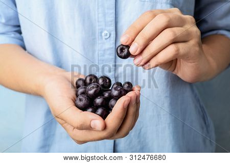 Female Holding Fresh Acai Berries, Closeup View